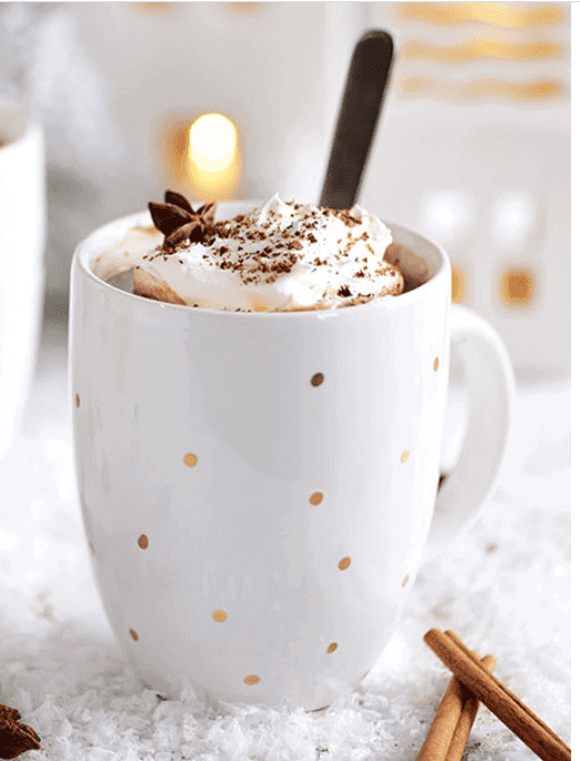 Butterscotch Schnapps Hot Chocolate in white mug with gold polka dots with cinnamon garnish