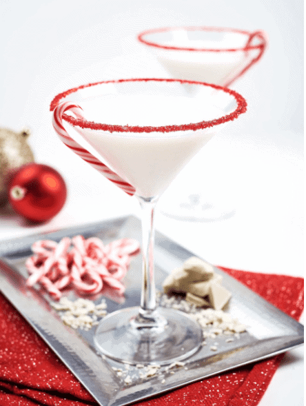 winter wonderland cocktail - martini with candy cane rim on a platter